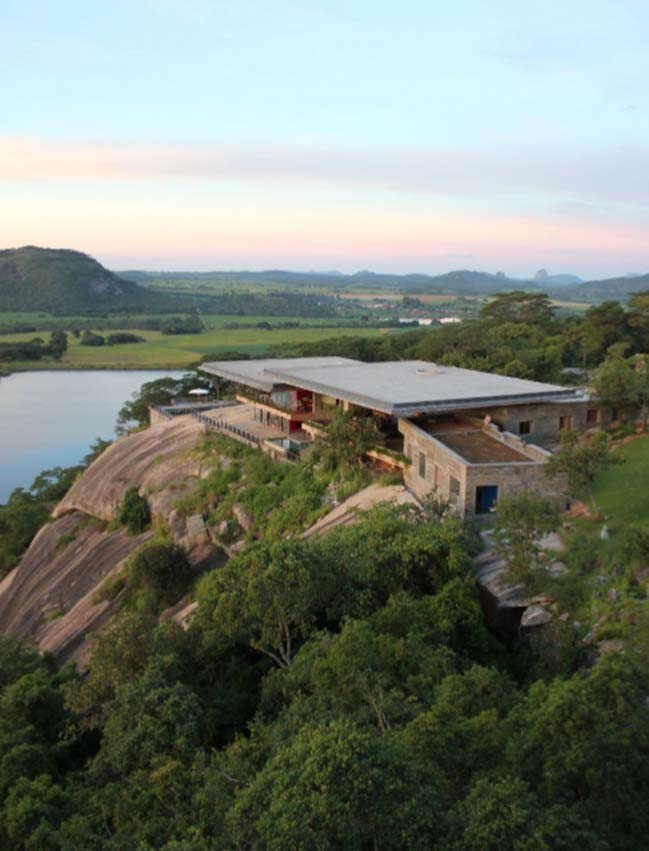 A dream house on a rock overlooking a man-made dam