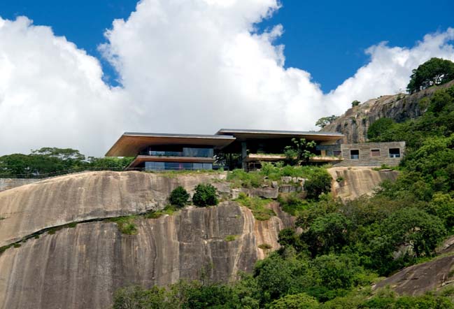 A dream house on a rock overlooking a man-made dam